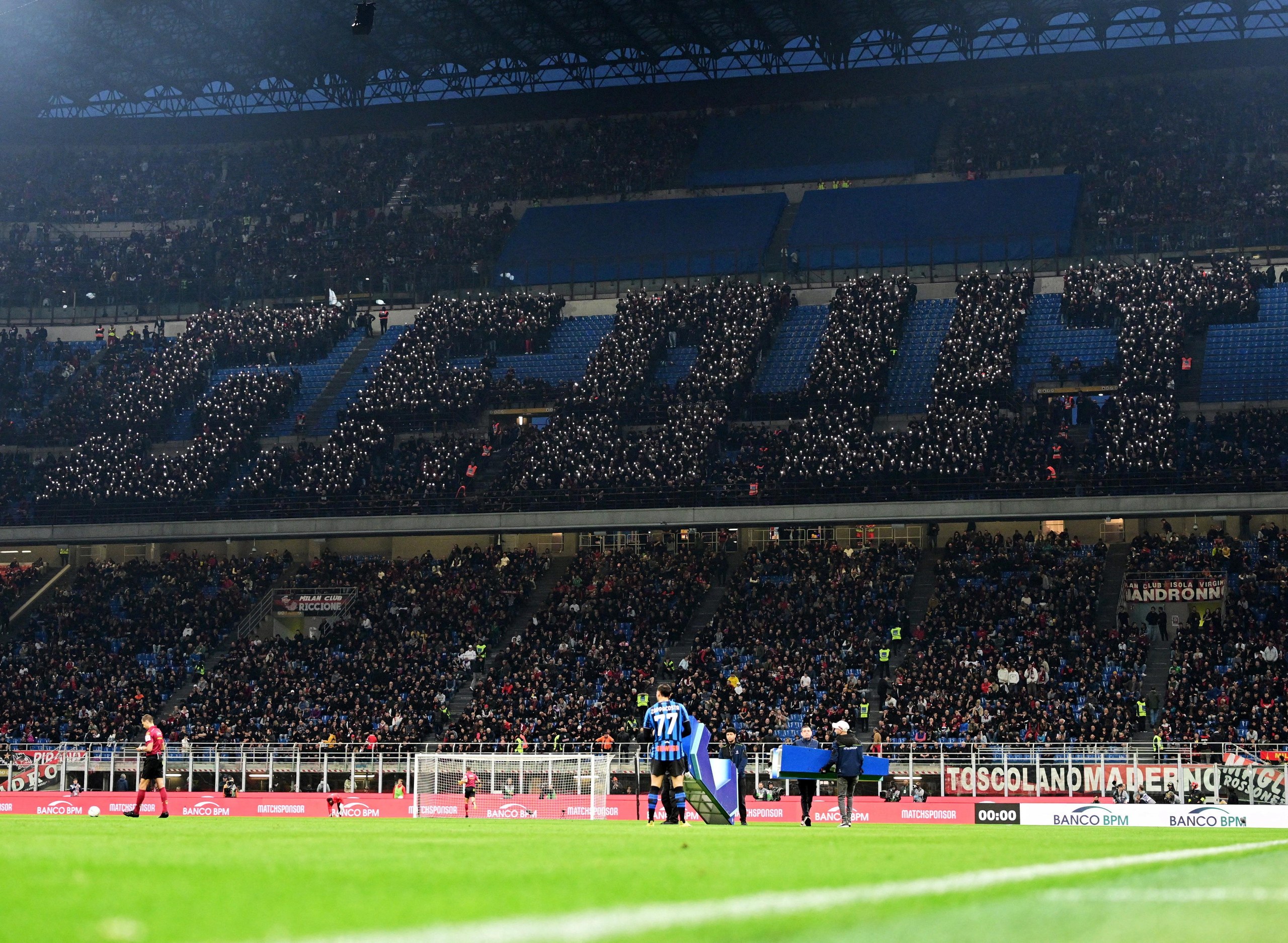 Milan fans use their mobile phone flashlights to spell the letters G.F. OUT before the Serie A match between Milan and Atalanta