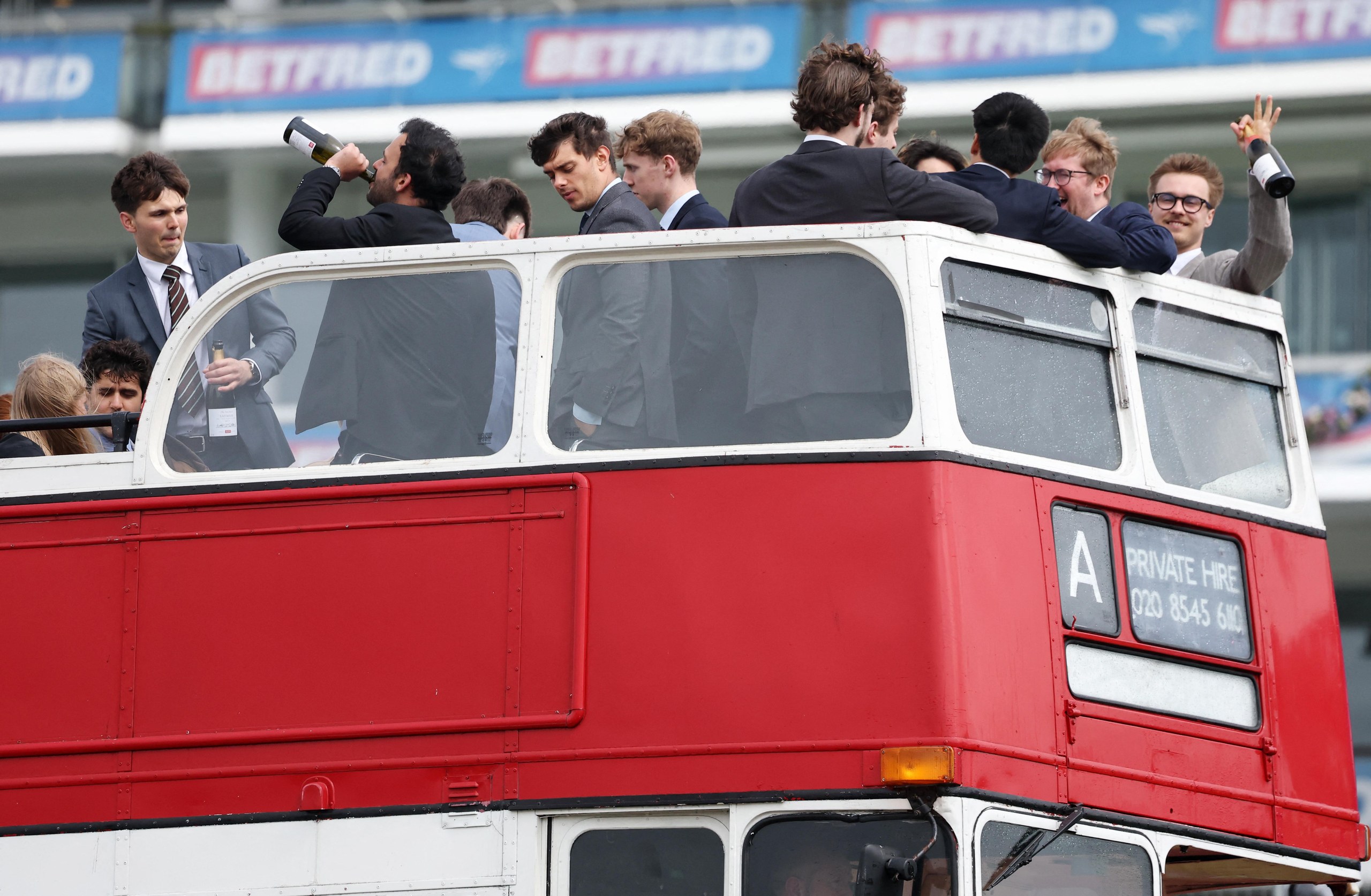 Racegoers on the top deck on an open bus at Epsom racecourse