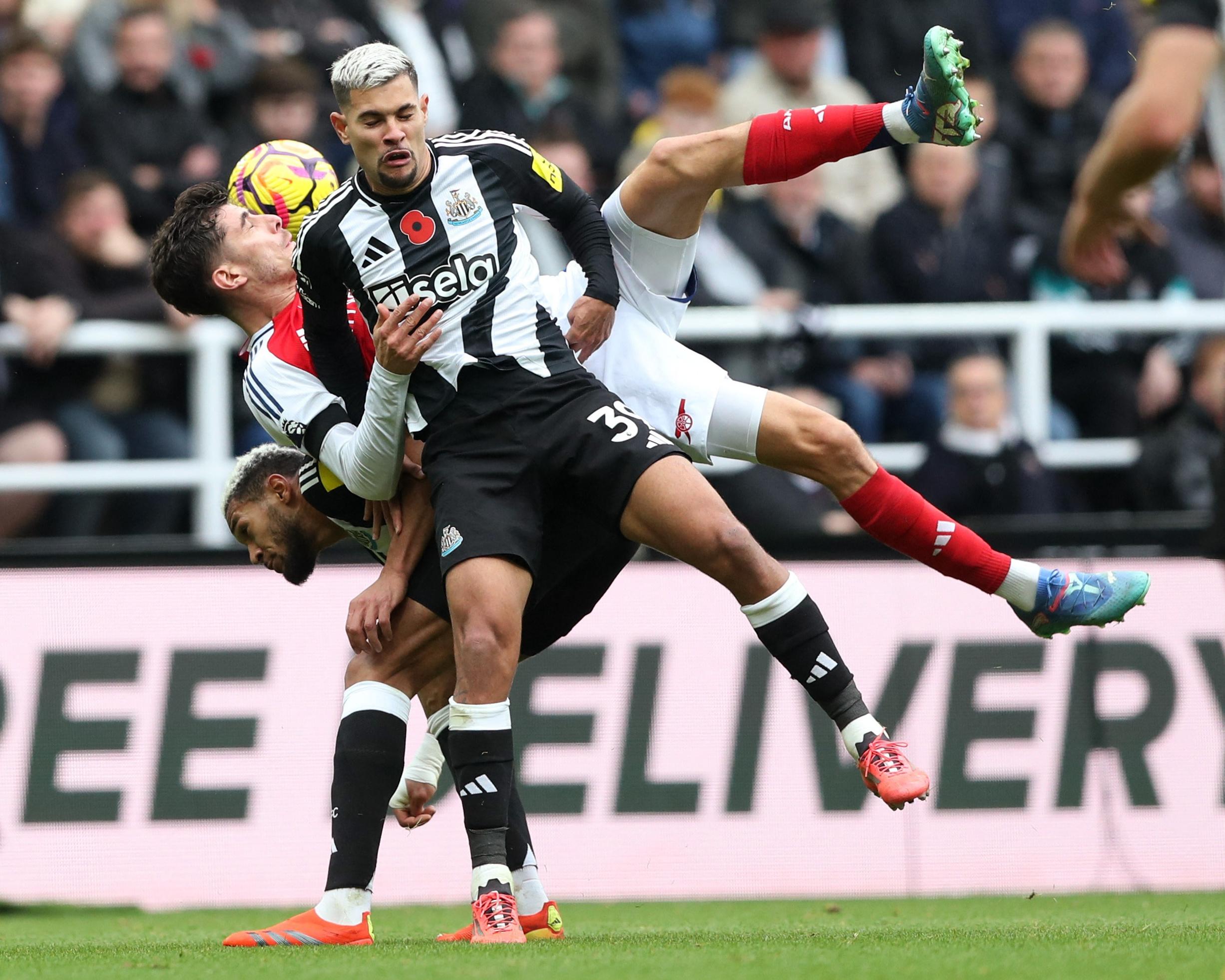 The Newcastle midfielder Bruno Guimarães battles for a loose ball with the Arsenal forward Kai Havertz.