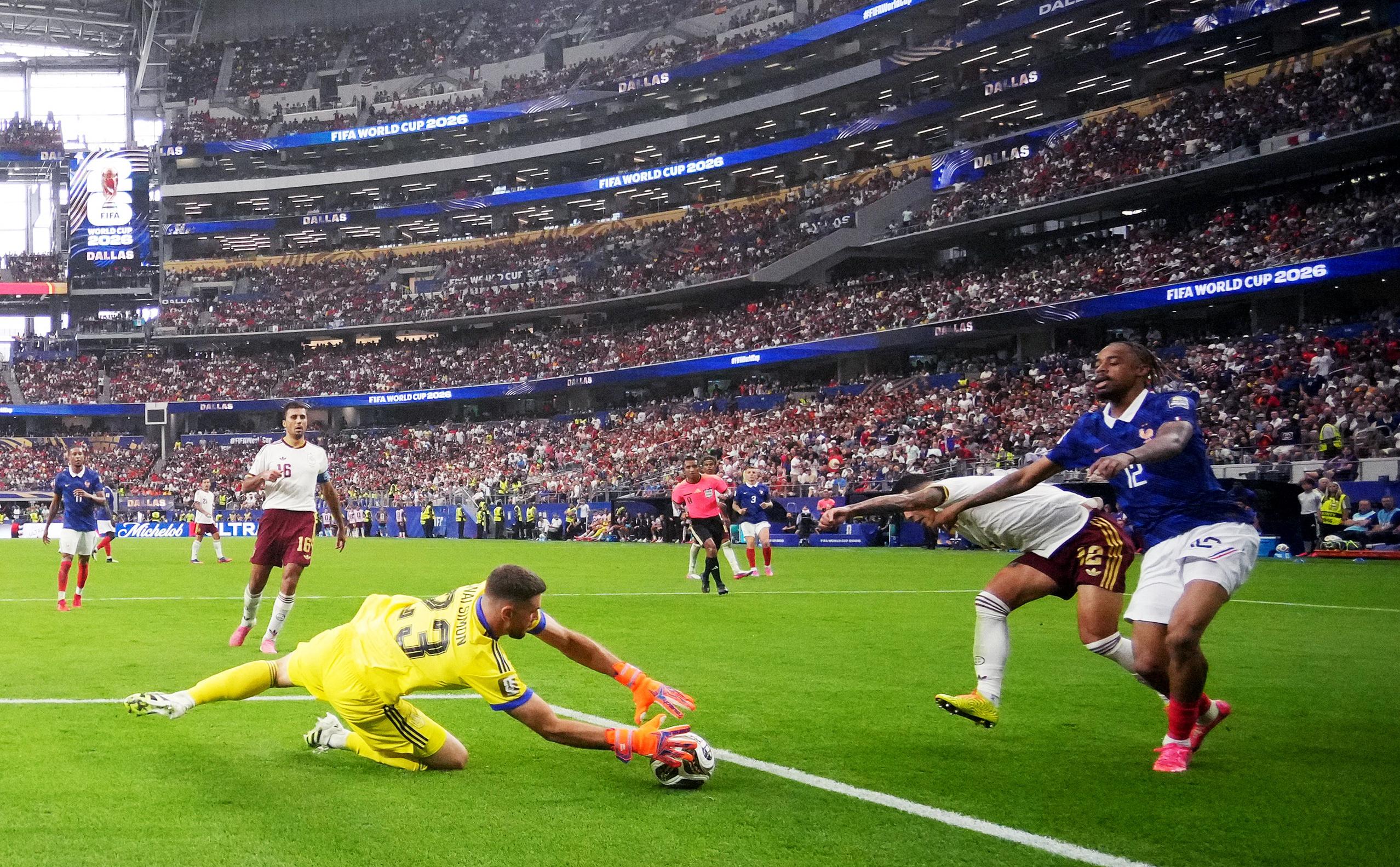 Spain's keeper Unai Simon claims the ball ahead of France's Bradley Barcola.