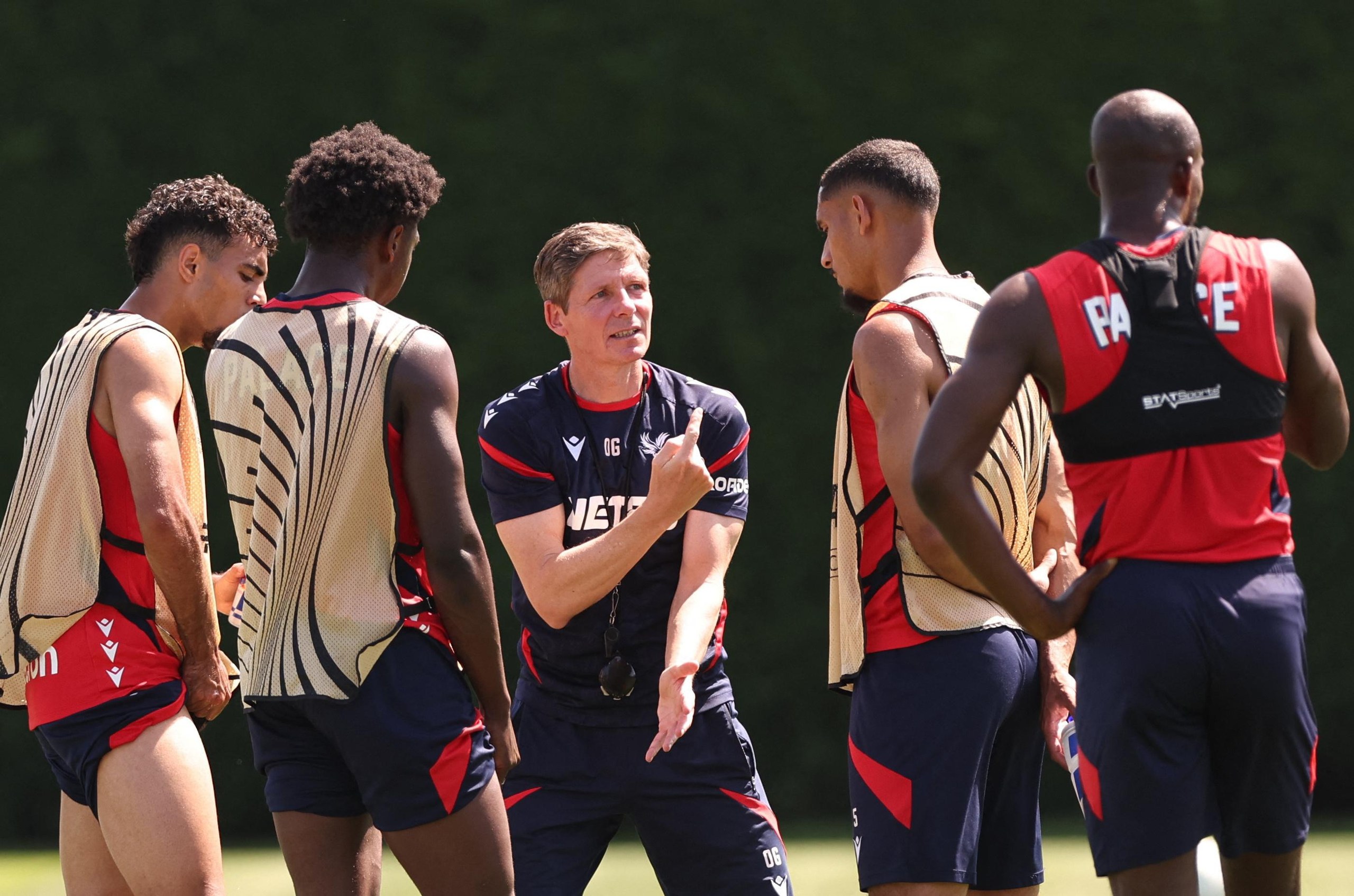 Oliver Glasner speaks to some of his players in training