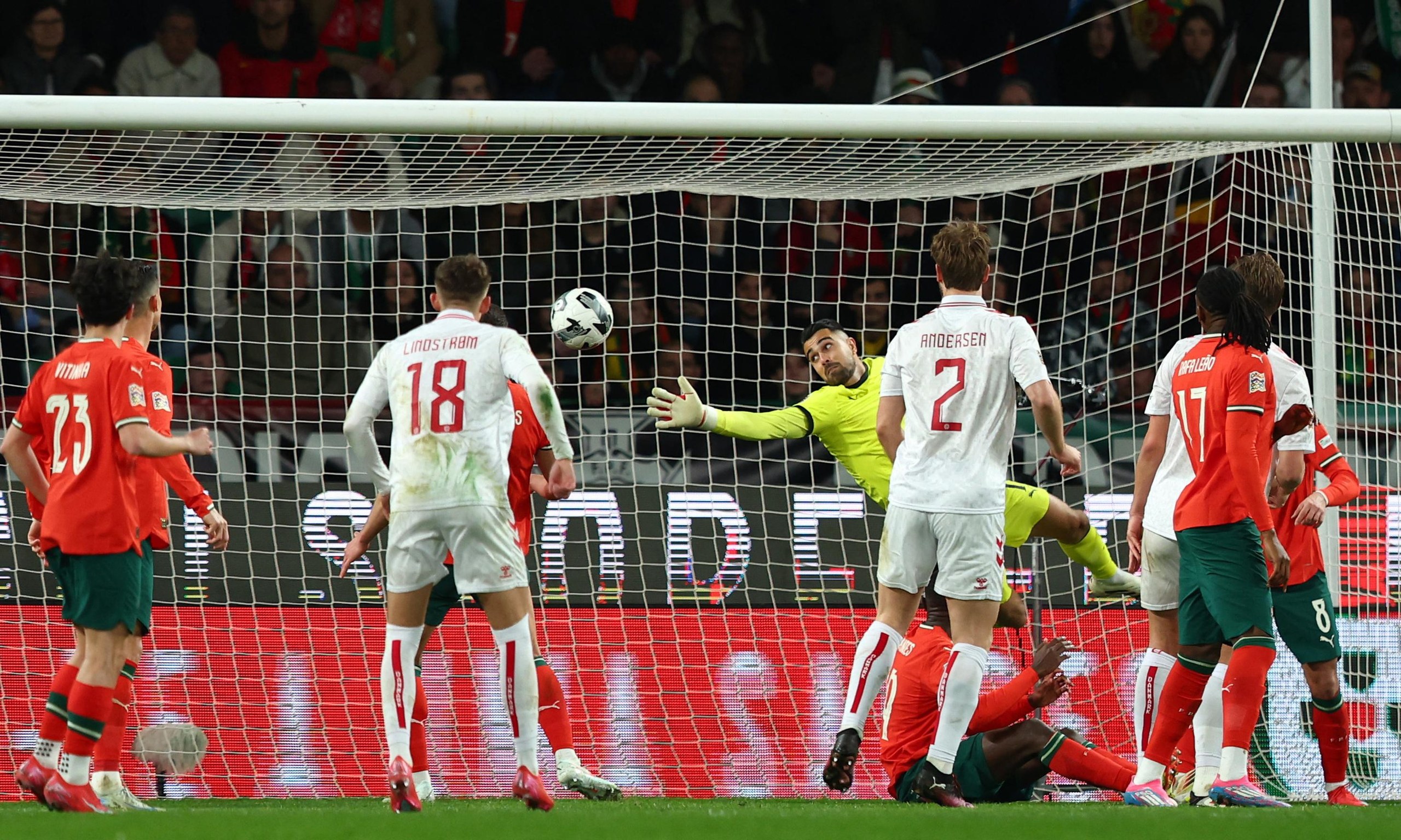 Portugal's Diogo Costa in action as Denmark's Rasmus Kristensen scores their first goal.
