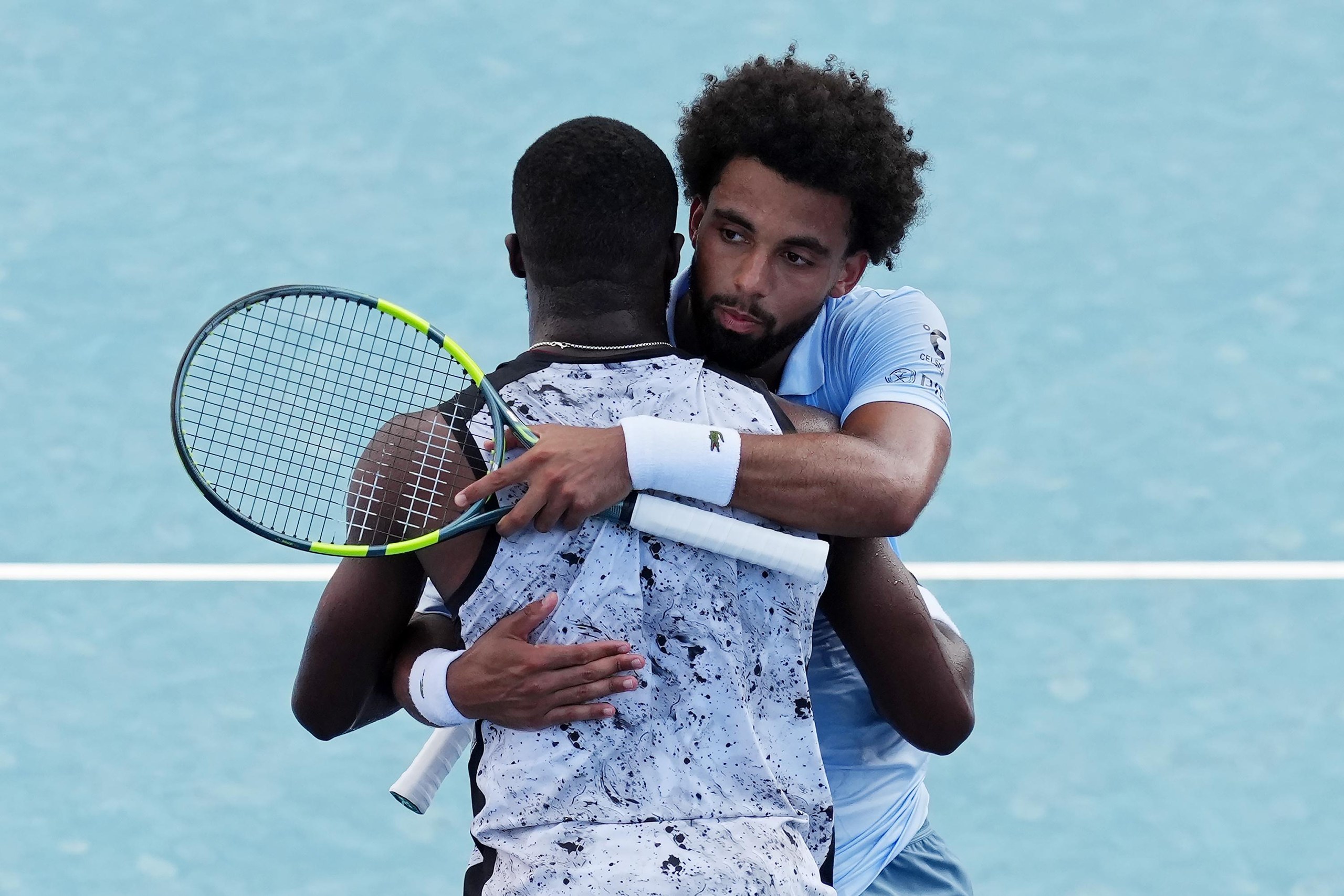 Arthur Fils (right) embraces Frances Tiafoe at the net after their three-set final.