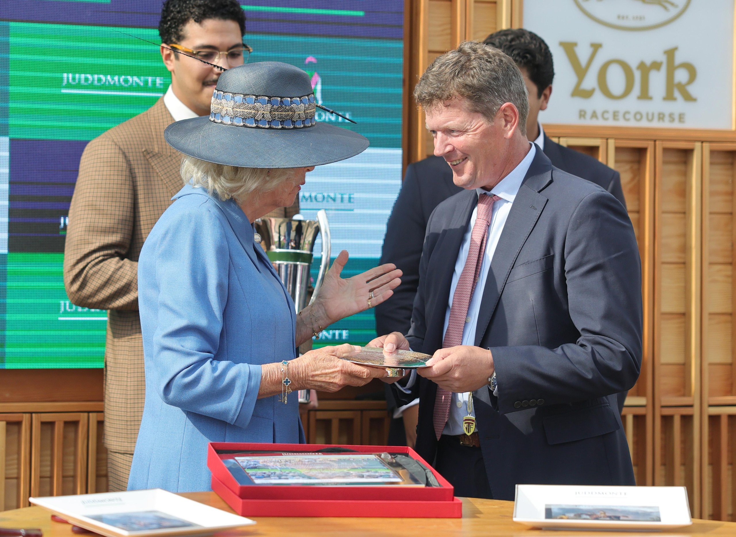 Andrew Balding receives a trophy from Queen Camilla after winning the Juddmonte International Stakes on the first day of the Ebor festival at York