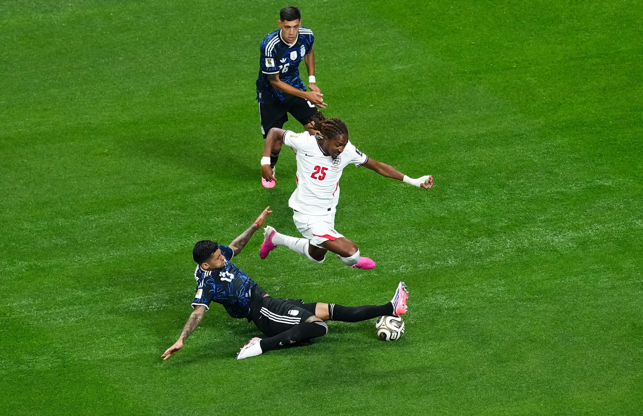 Djed Spence jumps over an Argentina player during England's match in the World Cup