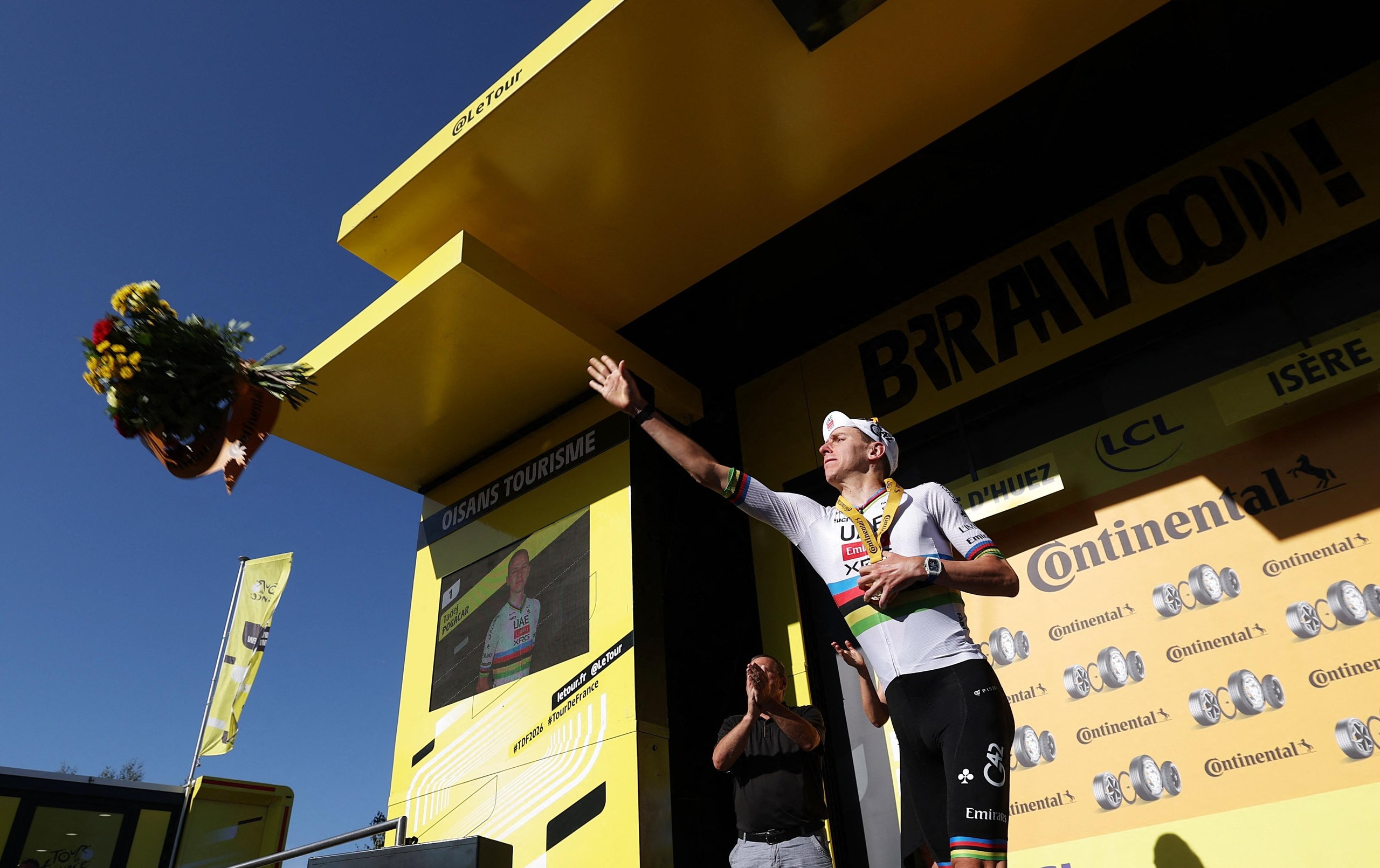 Tadej Pogacar celebrates on the podium after stage 19.