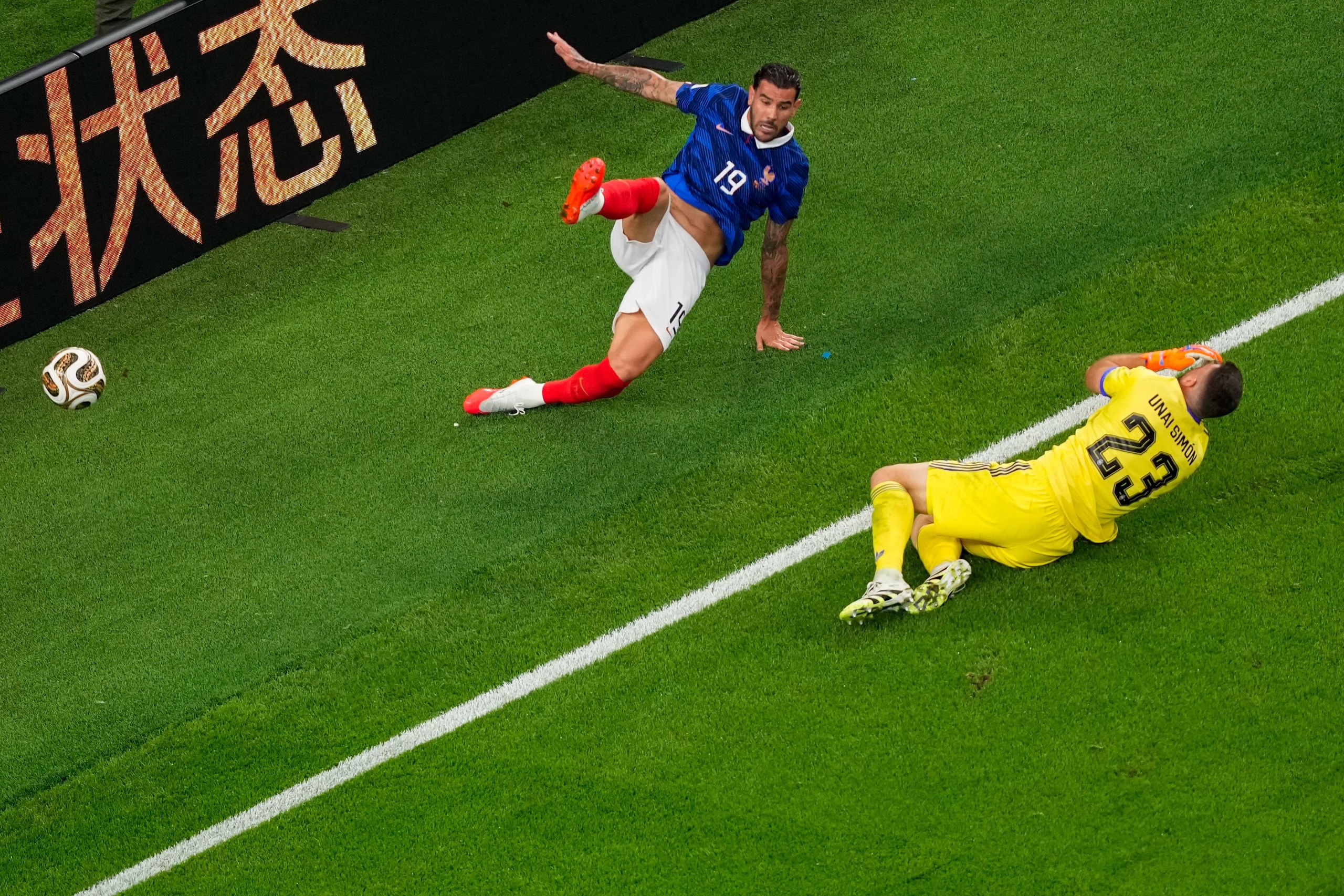 Spain’s goalkeeper Unai Simon falls after colliding with France's Theo Hernandez.