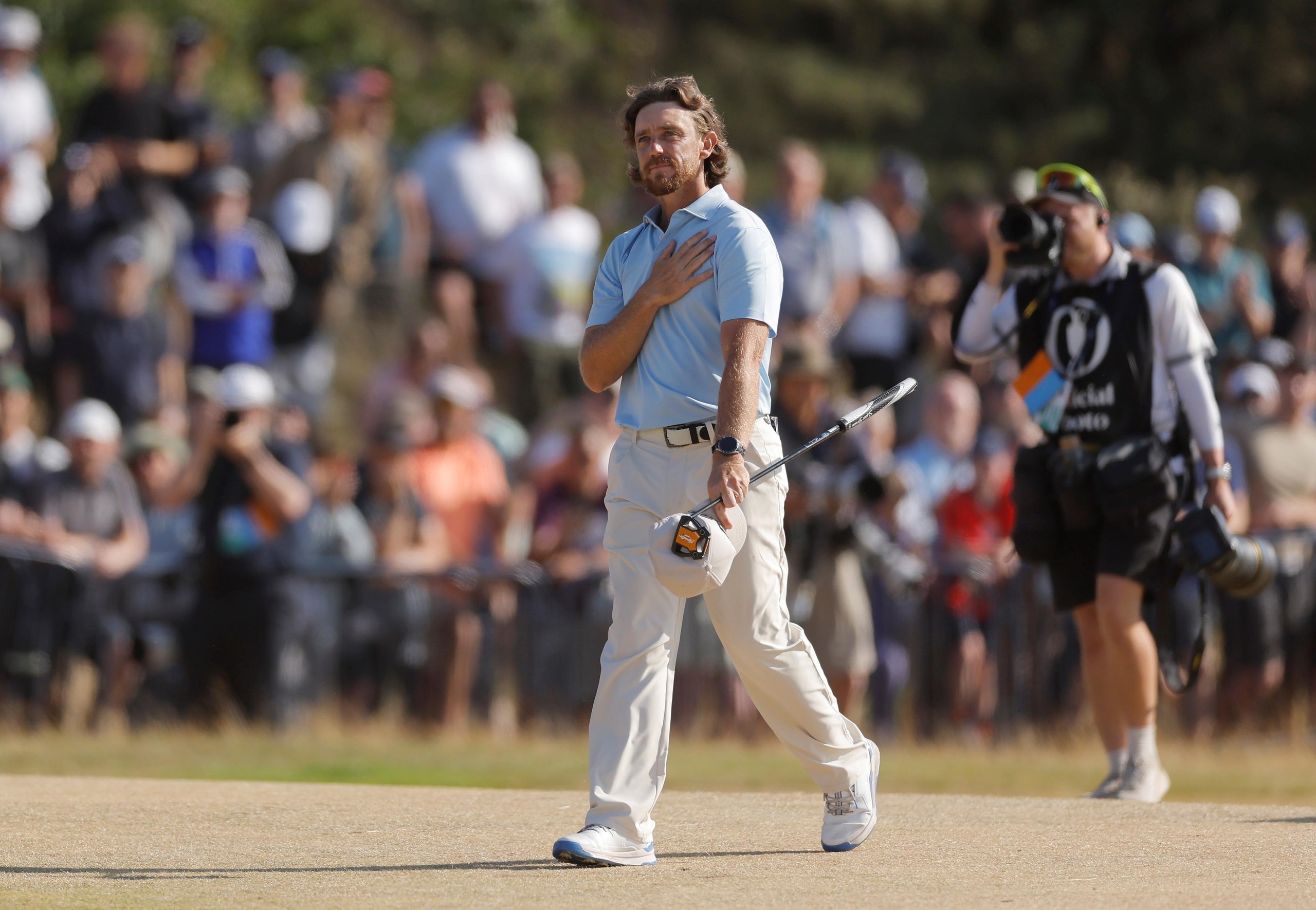 Tommy Fleetwood puts a hand to his heart as he walks up the fairway on the 18th hole on Sunday