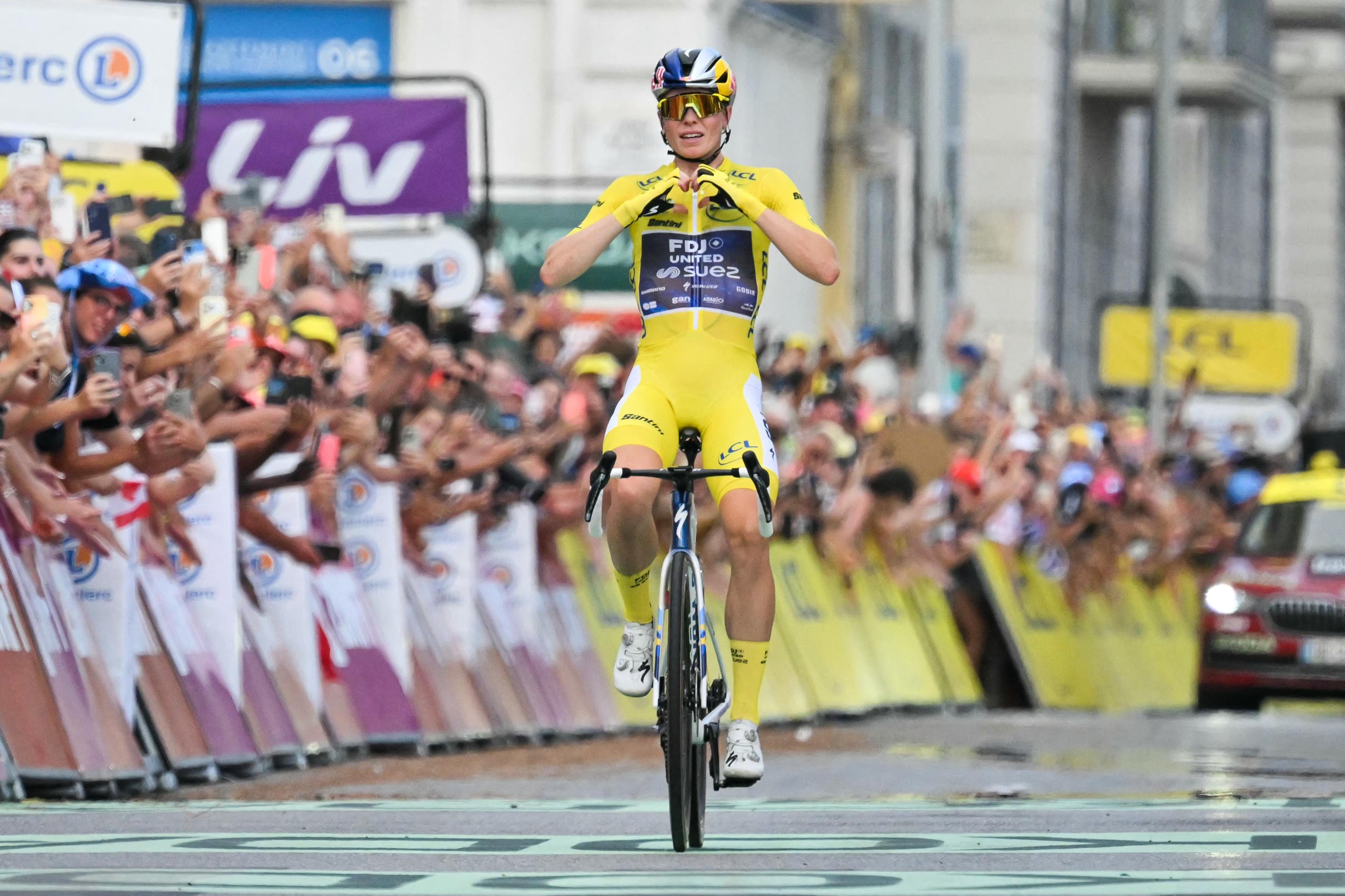 Demi Vollering crosses the line to win her second Tour de France Femmes title.