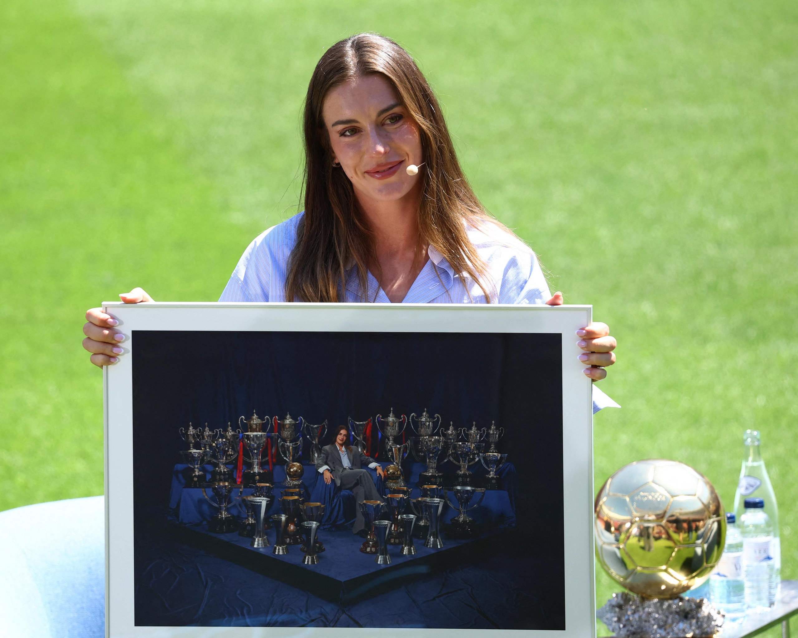 Alexia Putellas poses with a photo of herself surrounded by all of the trophies she’d won while at Barcelona.