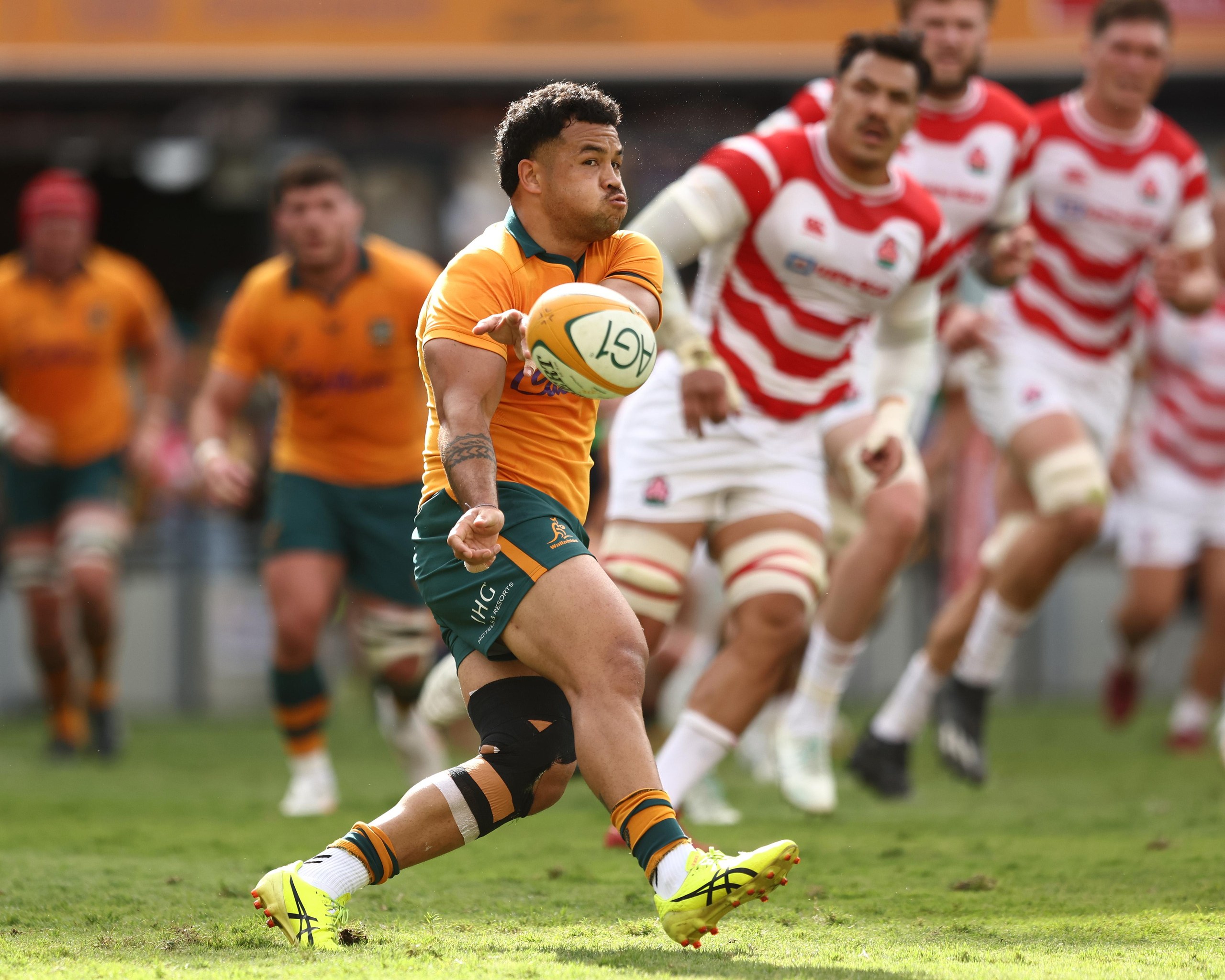 Hunter Paisami passes the ball for the Wallabies against Japan