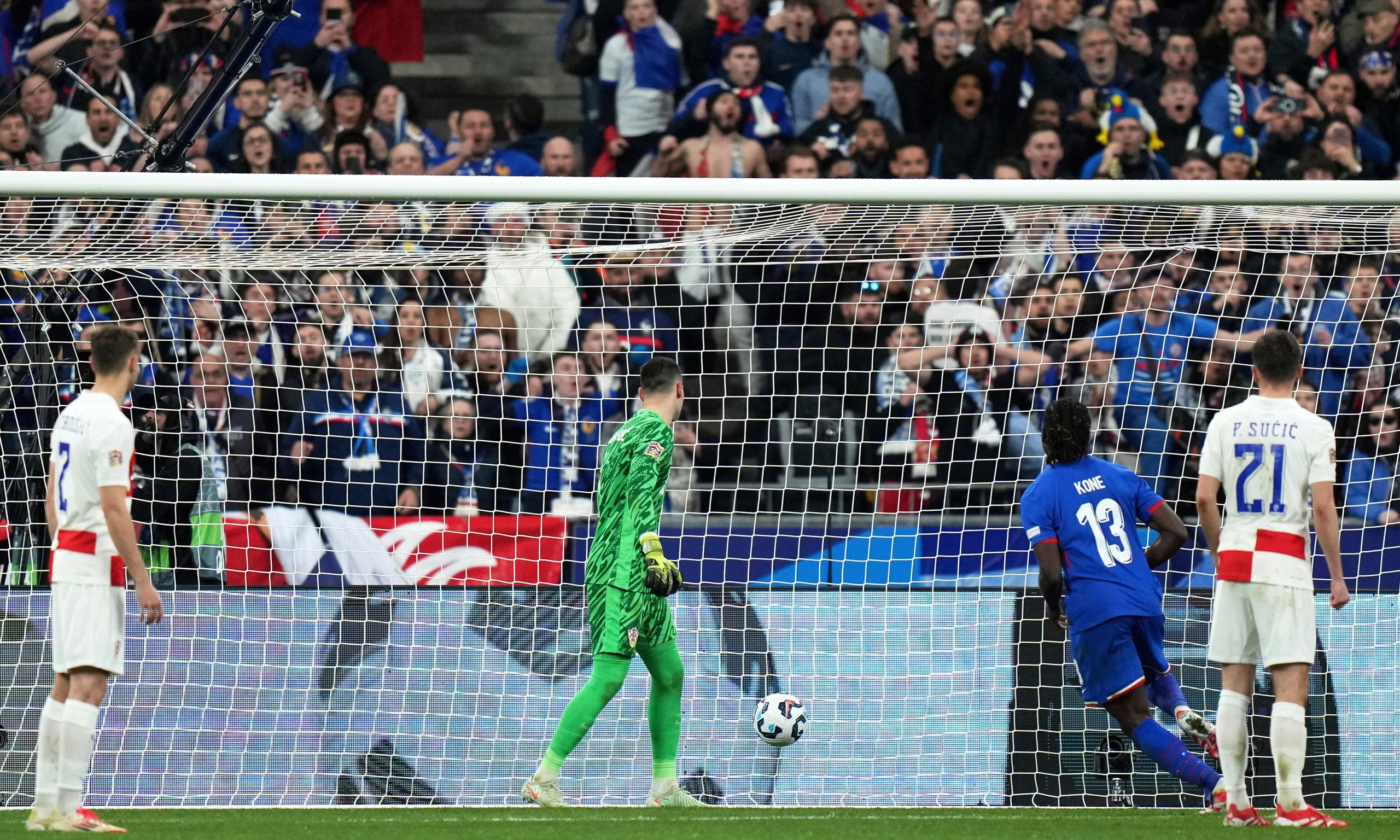 Croatia's goalkeeper Dominik Livakovic, center, watches the ball go into the net for a goal by France's Michael Olise.