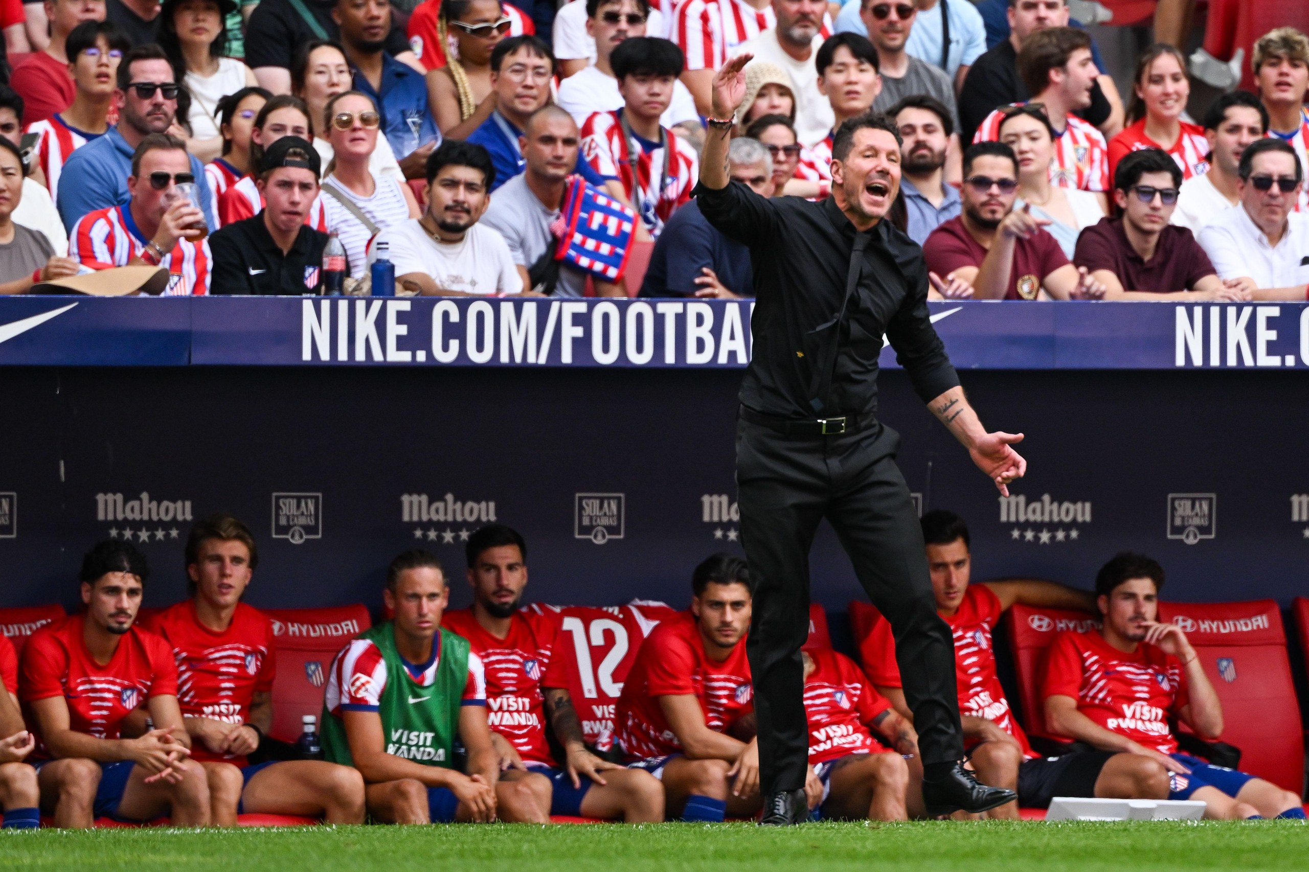 Diego Simeone stands in front of his substitutes