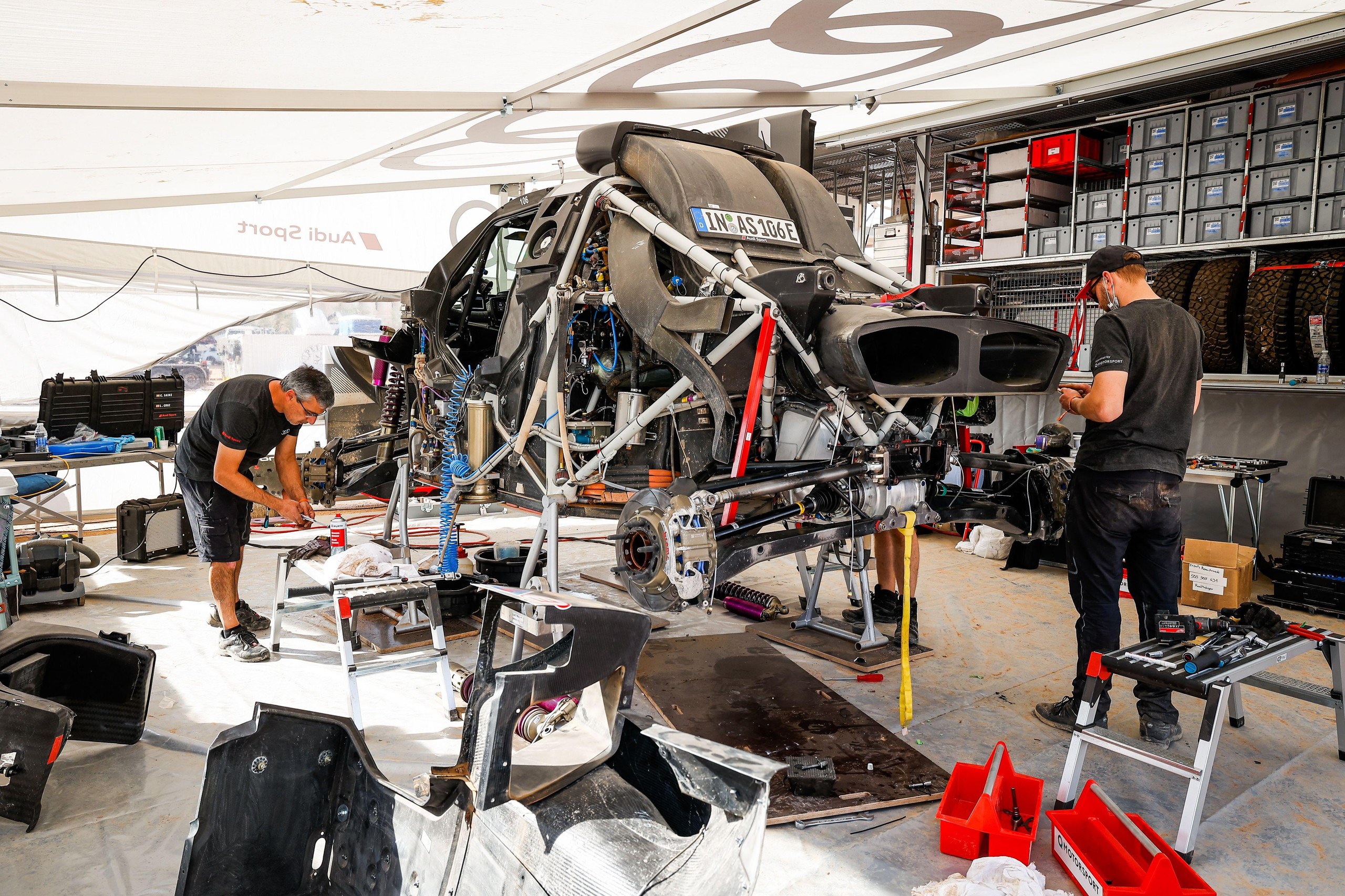 Mechanics work on Carlos Sainz and Lucas Cruz’s Audi RS Q E-Ttron car during the rally rest day.