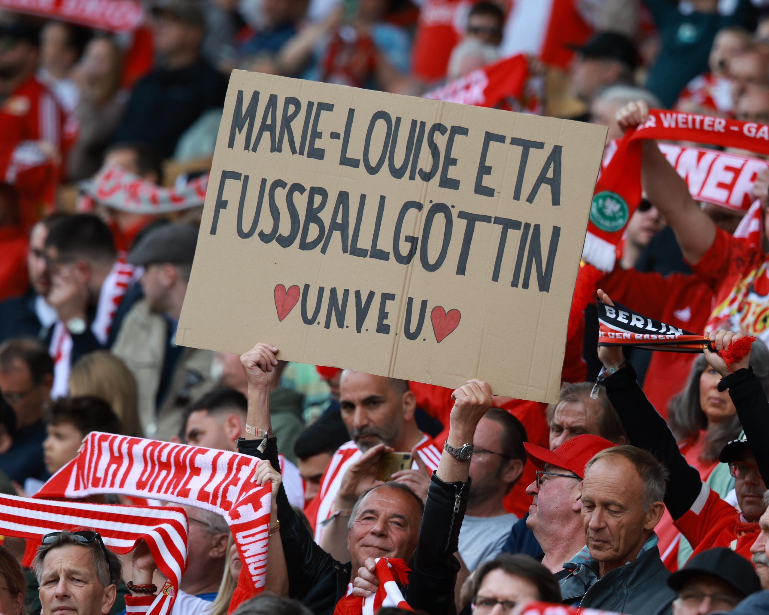 A Union Berlin fan holds a placard that reads: ‘Marie-Louise Eta Football Goddess UNVEU’