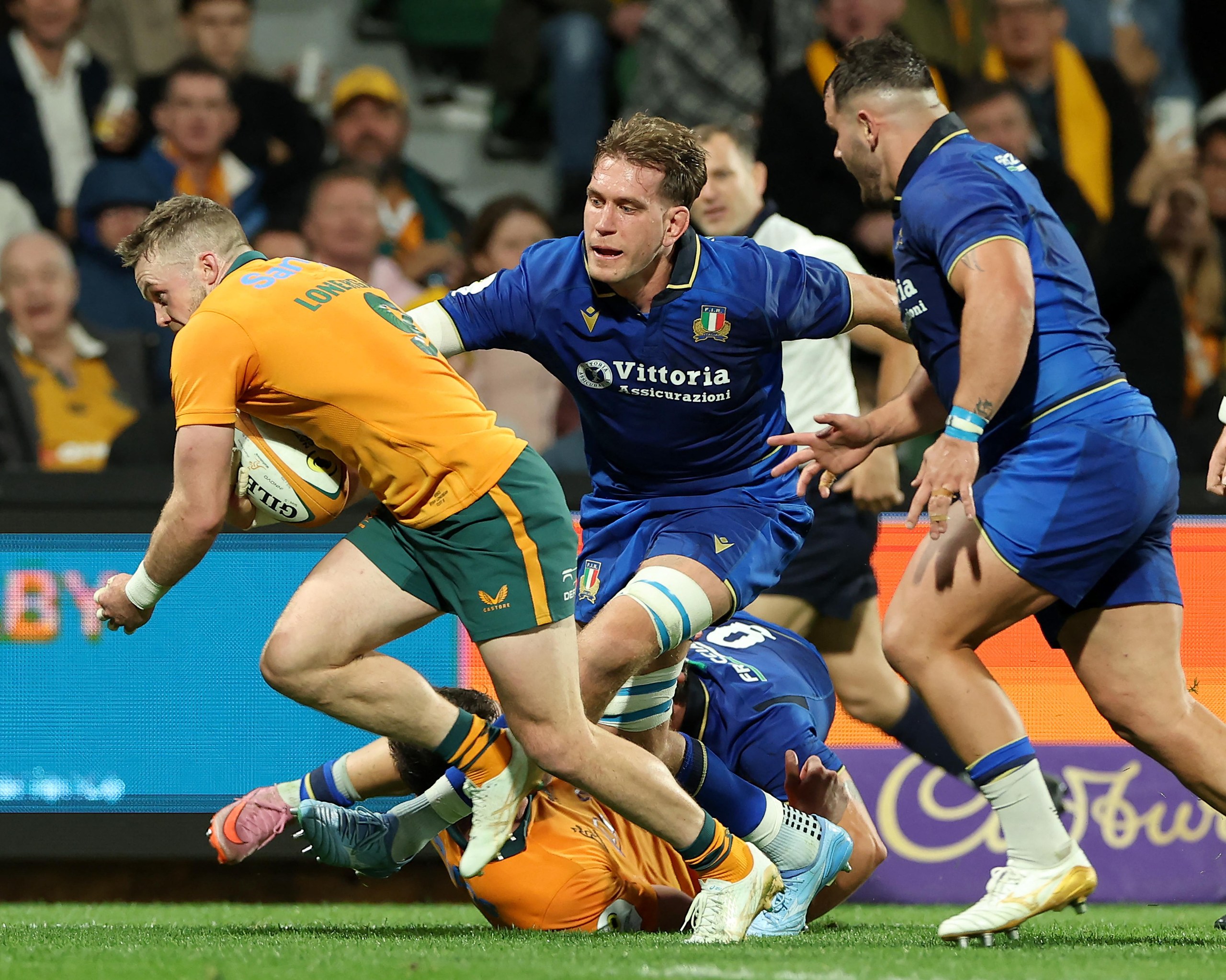 Australia’s Ryan Lonergan evades a tackle by Italy’s Federico Ruzza