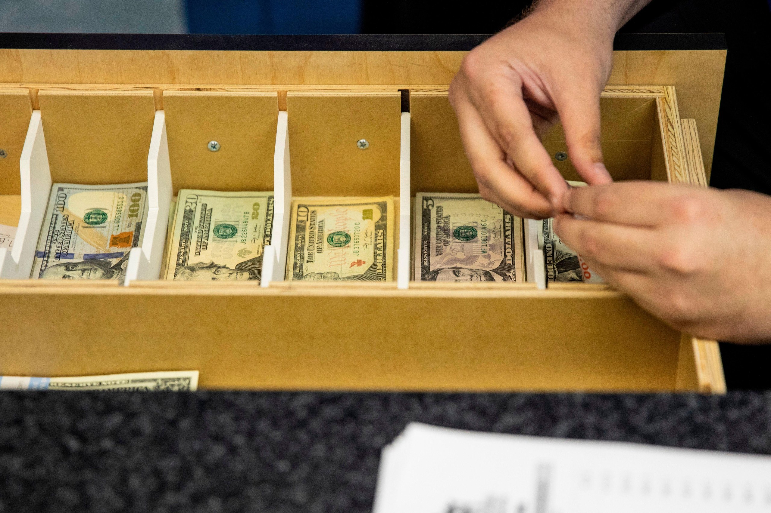 A teller counts cash at Monmouth Park, the 156-year-old racetrack in Oceanport, New Jersey.