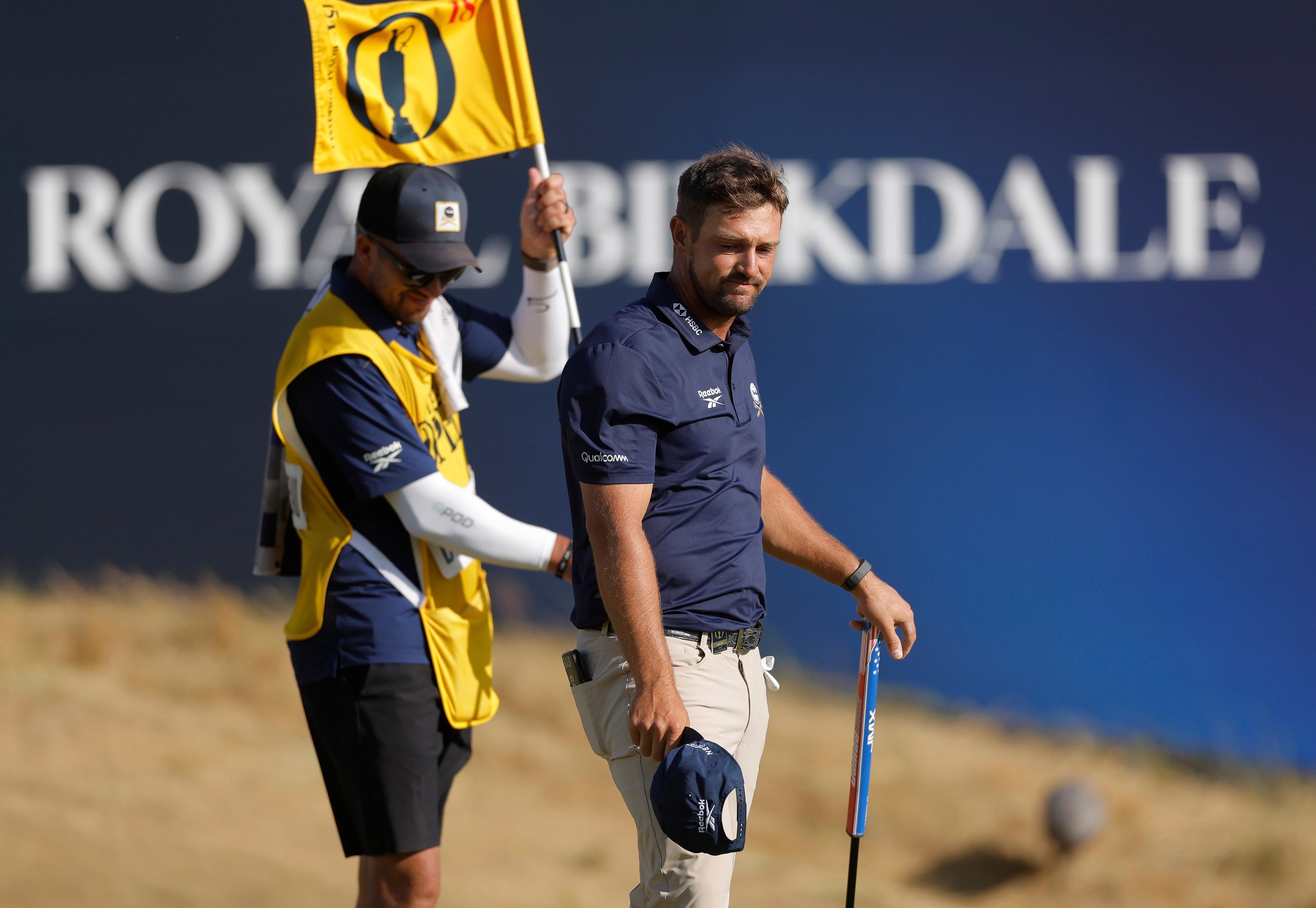 Bryson DeChambeau with his caddie after holing out on the 18th green