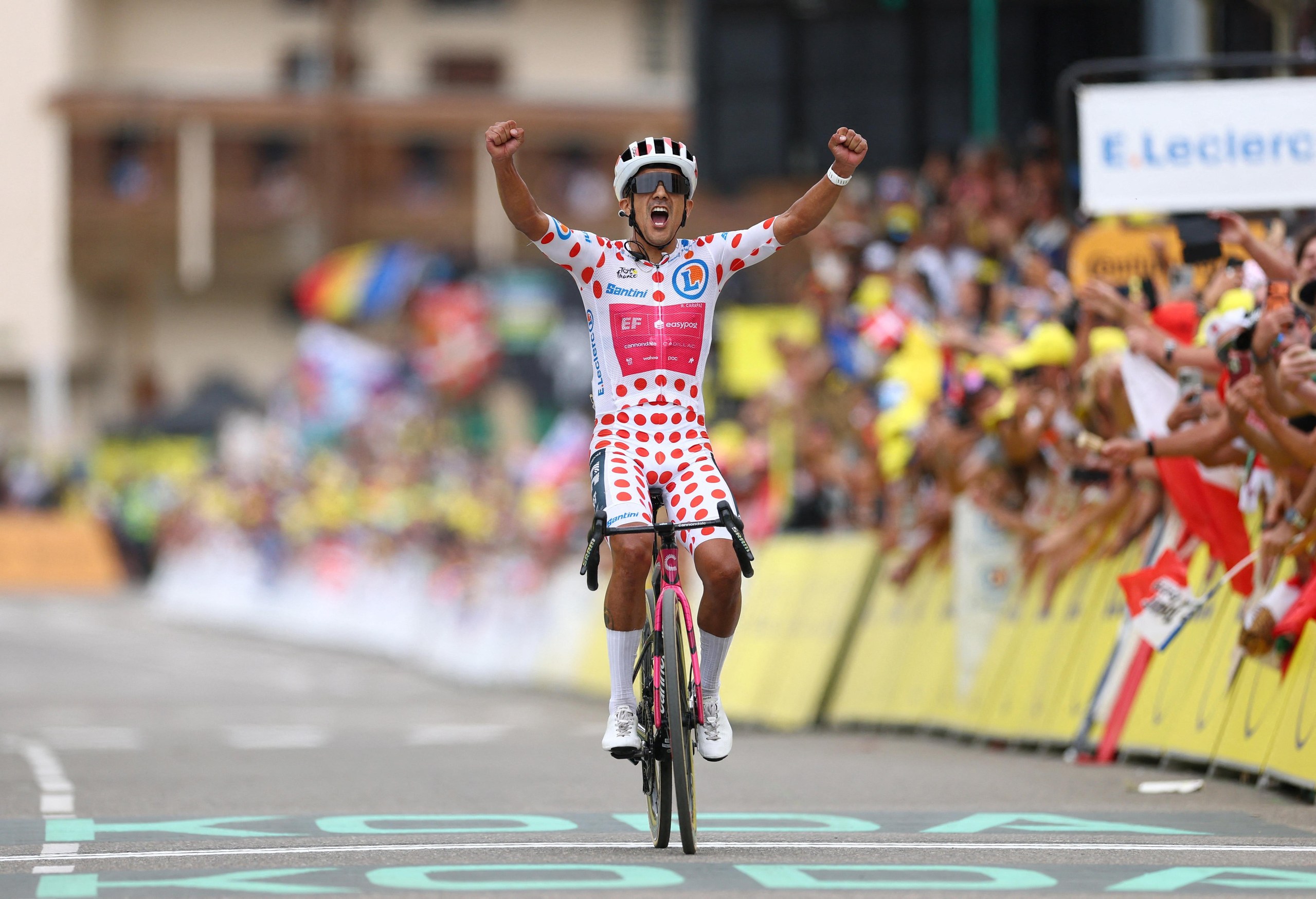 EF Education - EasyPost's Richard Carapaz, wearing the polka dot jersey, celebrates winning stage 20.