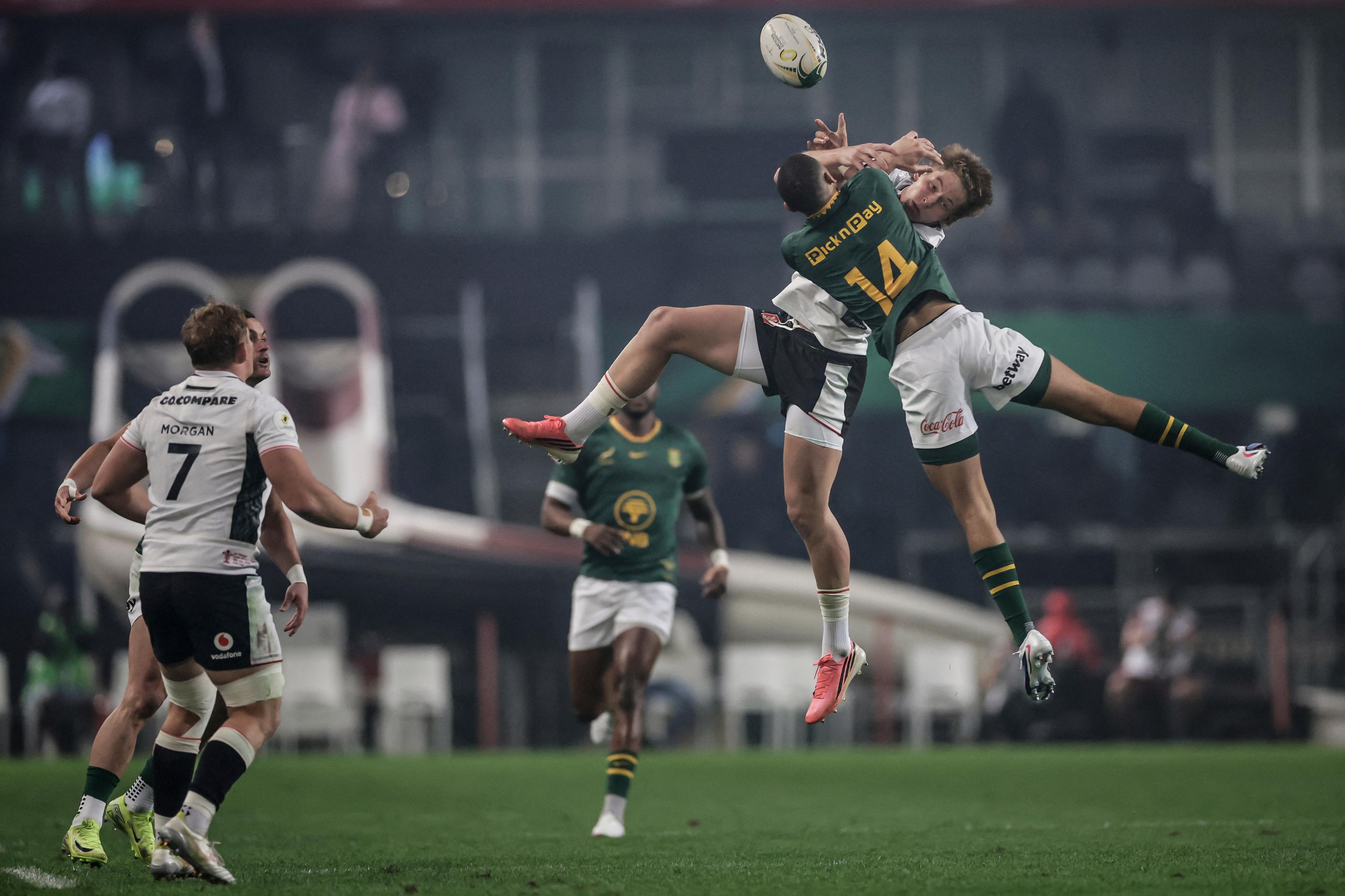 Jaco Williams jumps for the ball with Wales' Ellis Mee