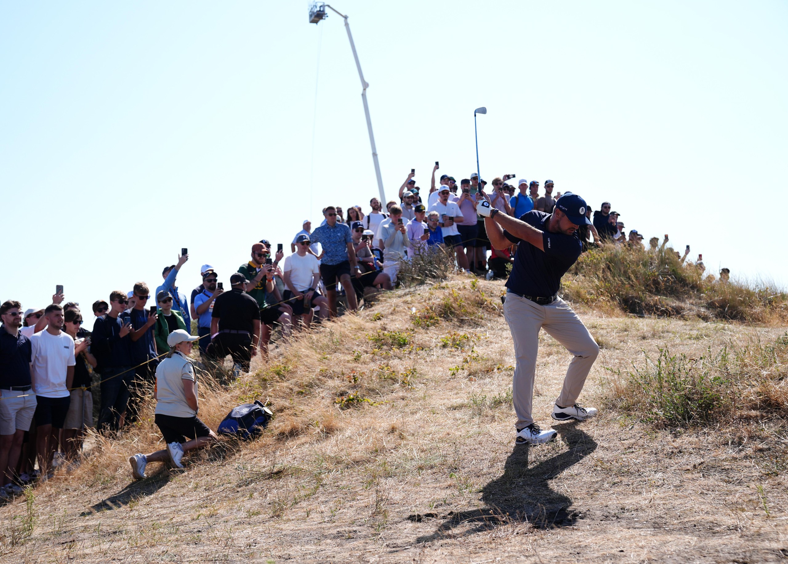 Bryson DeChambeau hits from the rough at the 11th hole.