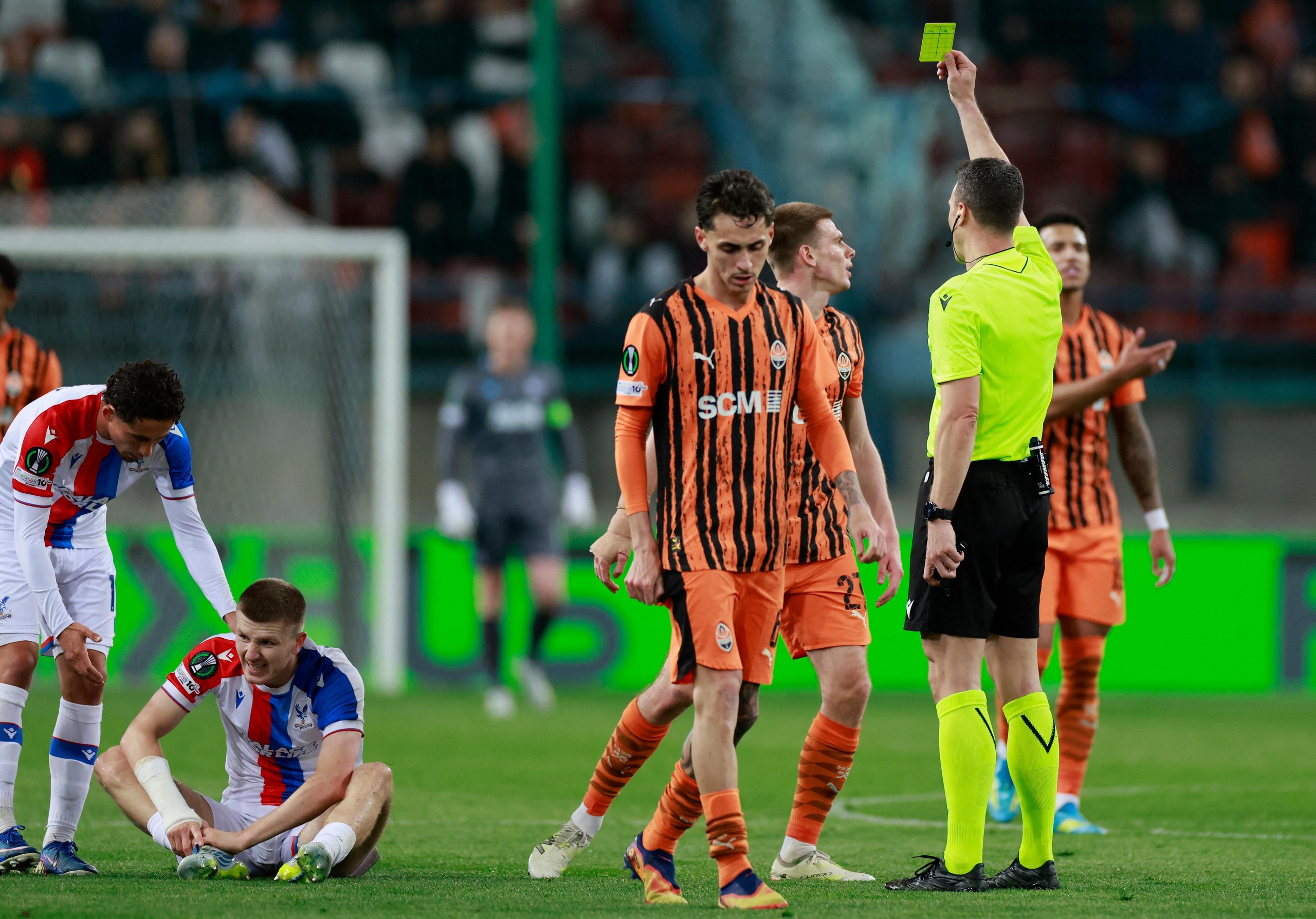 Referee Felix Zwayer shows a yellow card to Shakhtar Donetsk’s Oleg Ocheretko for a foul on Crystal Palace’s Adam Wharton (second left).