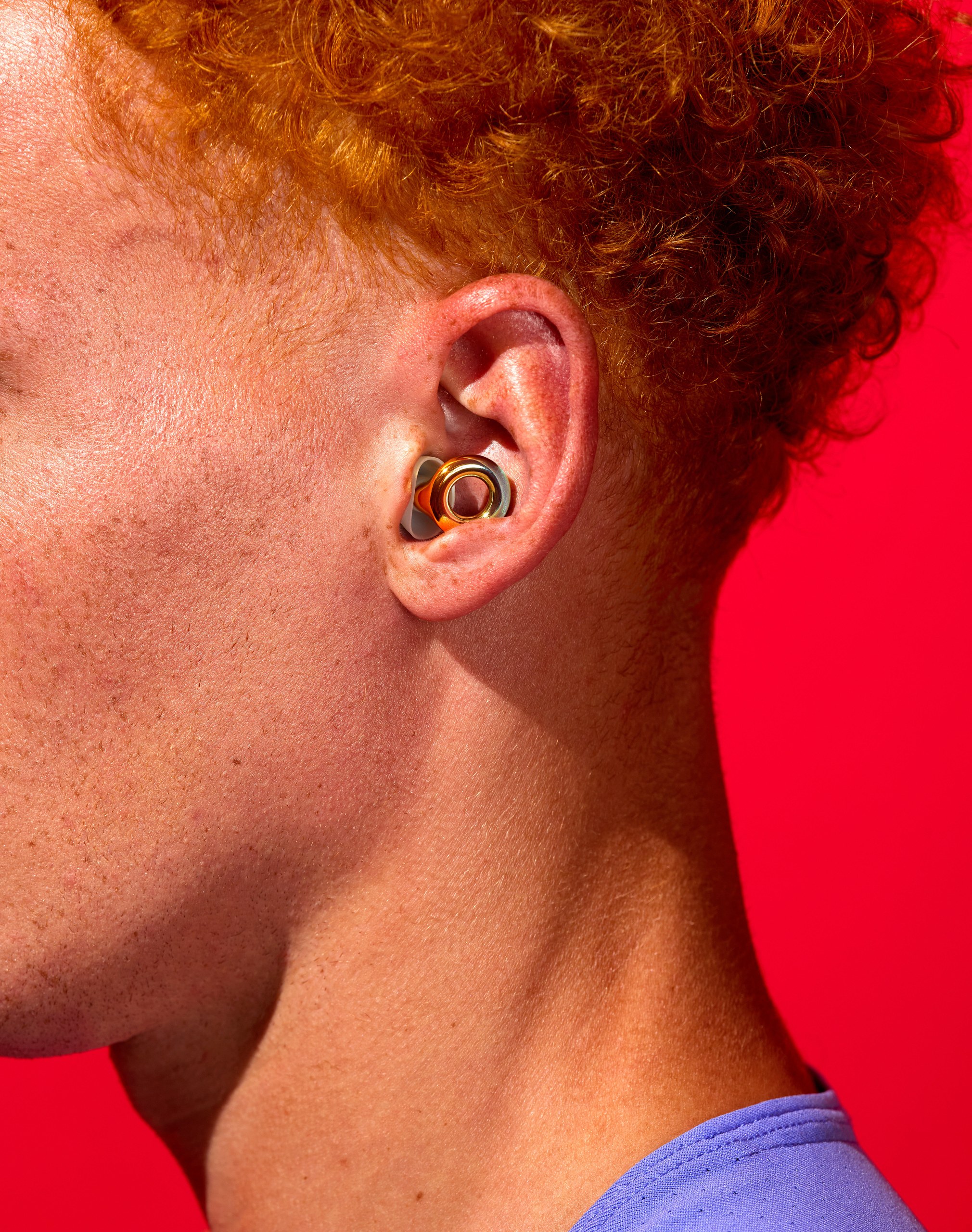 Picture of a man’s ear with an earplug in it