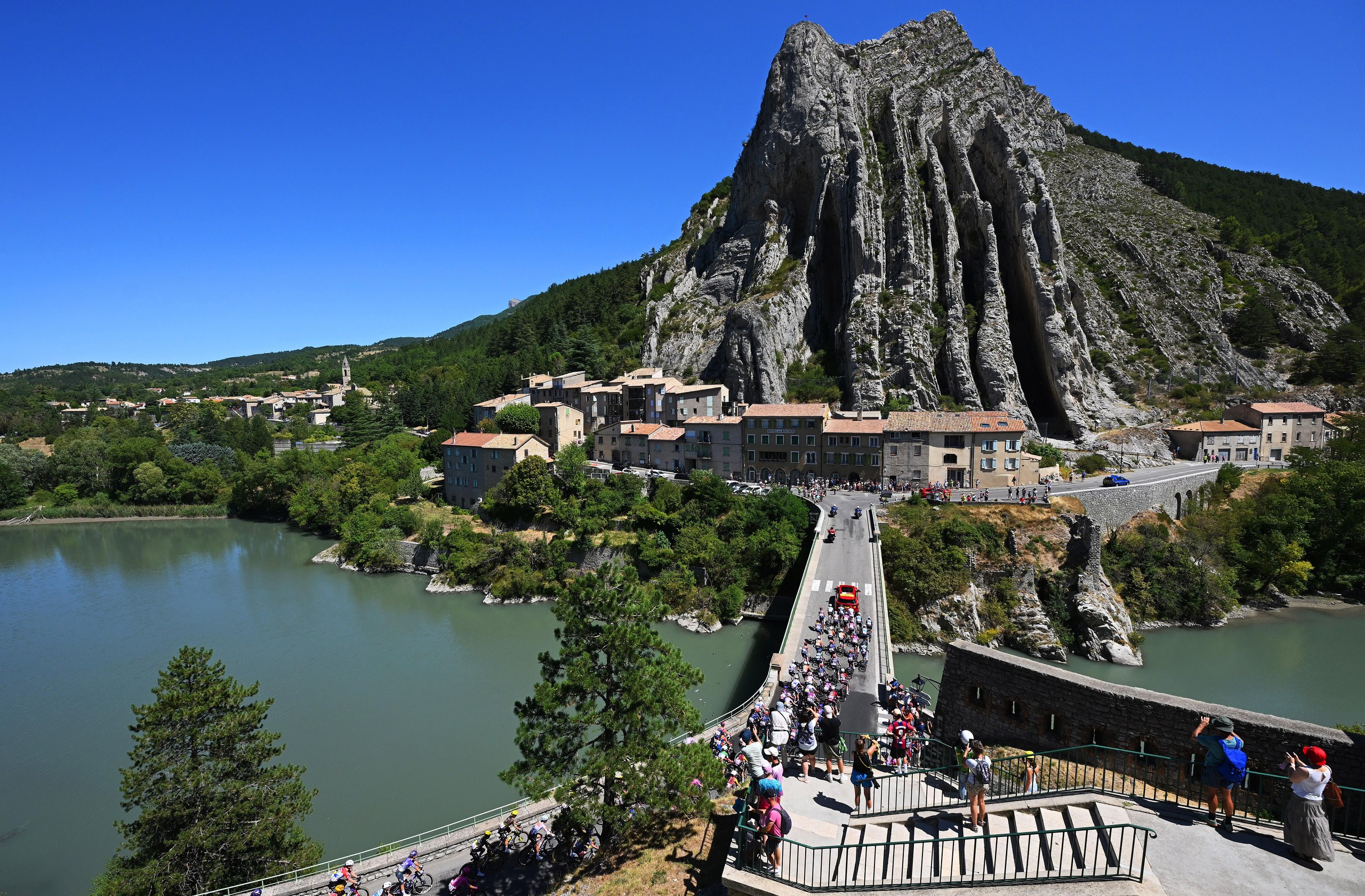The peloton pass by an impressive rock formation prior to the start of Stage 8.
