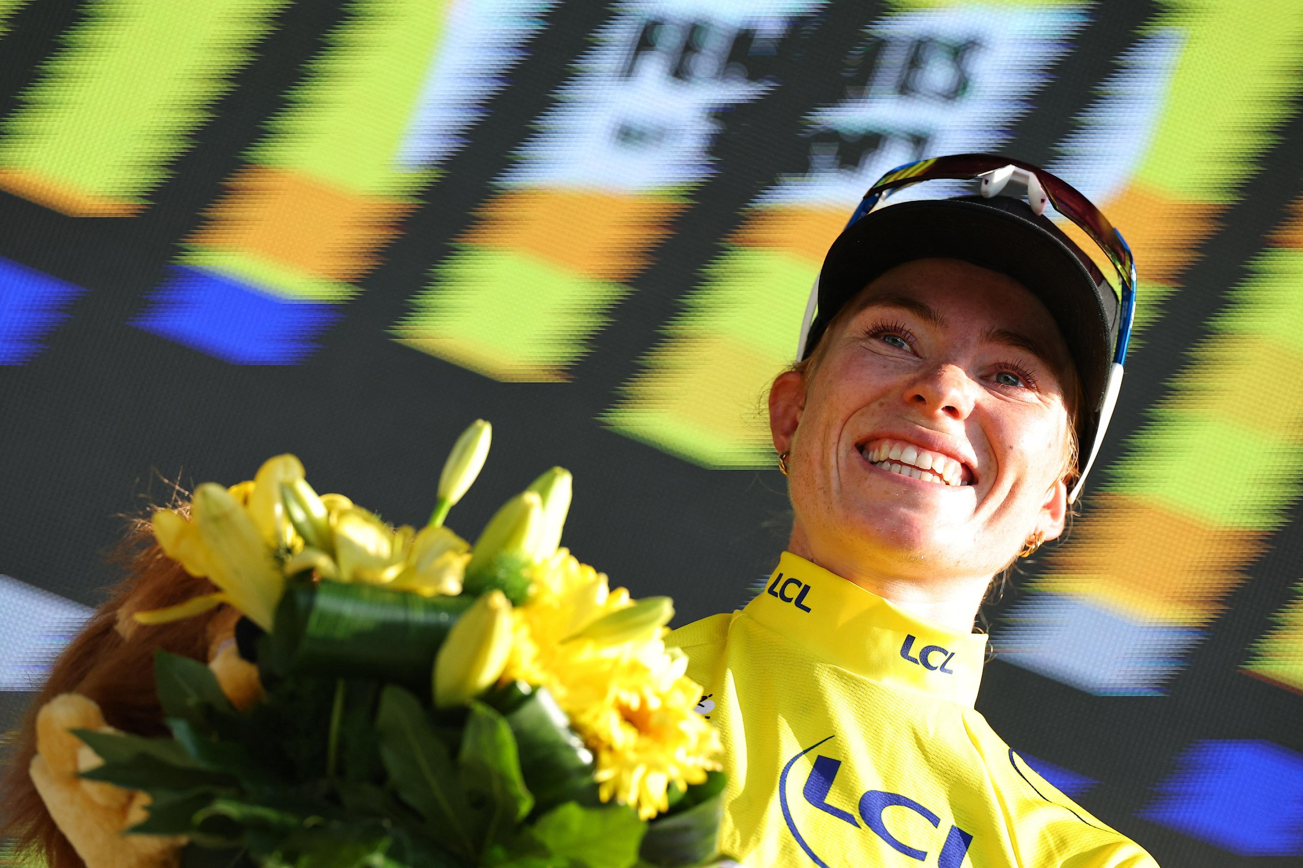 FDJ United-Suez's Demi Vollering celebrates on the podium wearing the yellow jersey after winning stage 8.