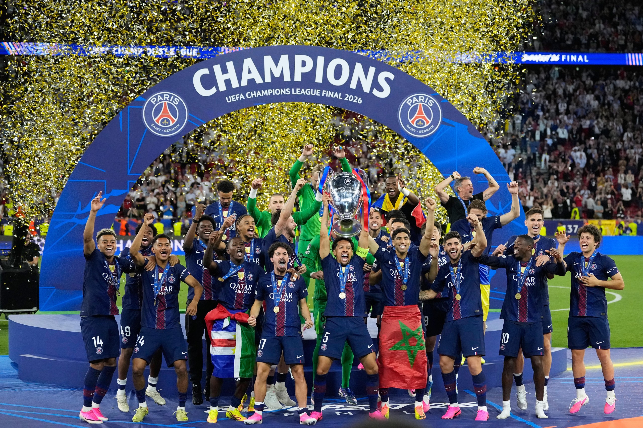 PSG's Marquinhos lifts the trophy as he and his teammates celebrate winning the Champions League final.