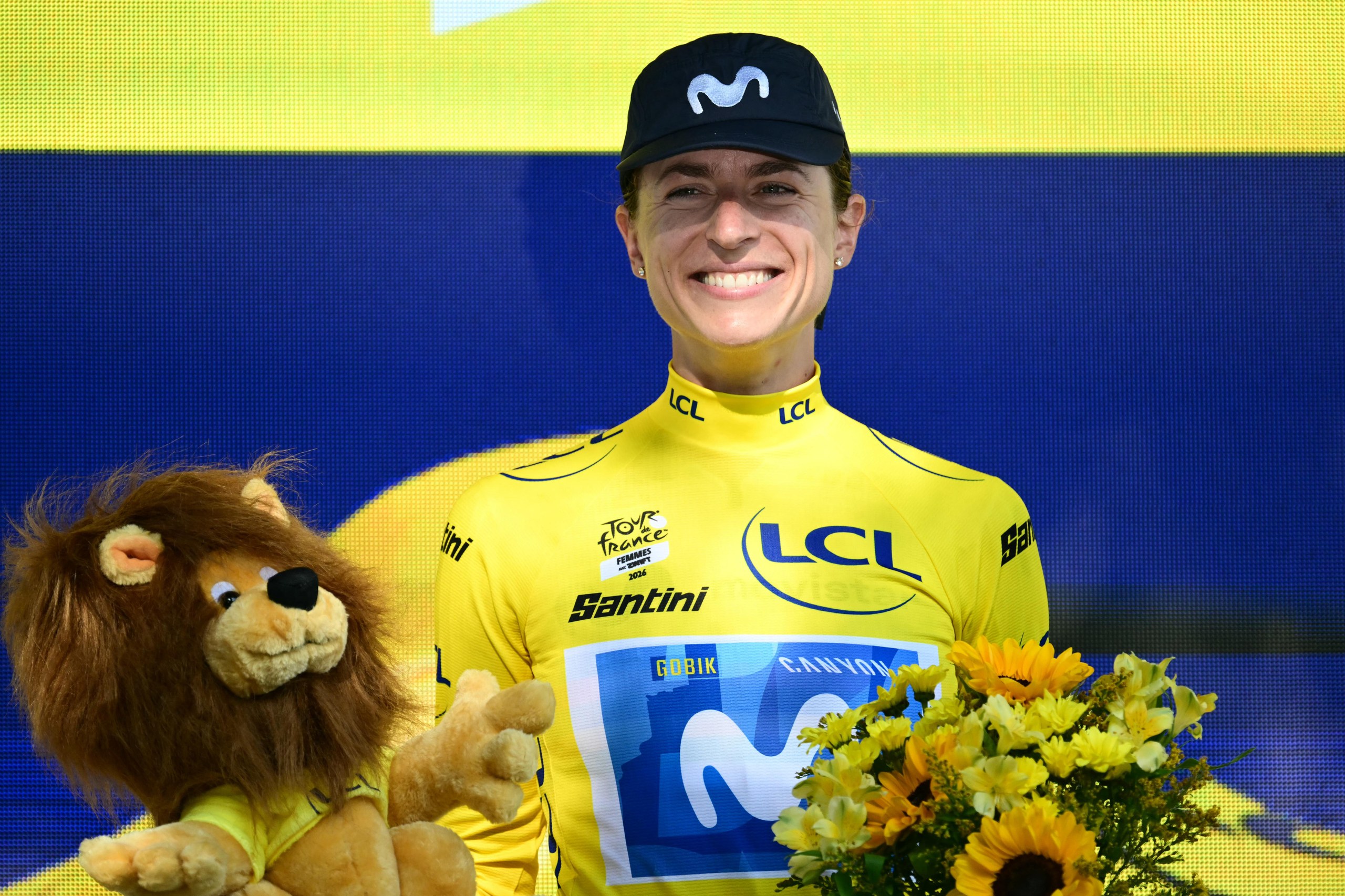 Movistar’s Marlen Reusser celebrates on the podium with the overall leader's yellow jersey after winning stage 4, the individual time trial.