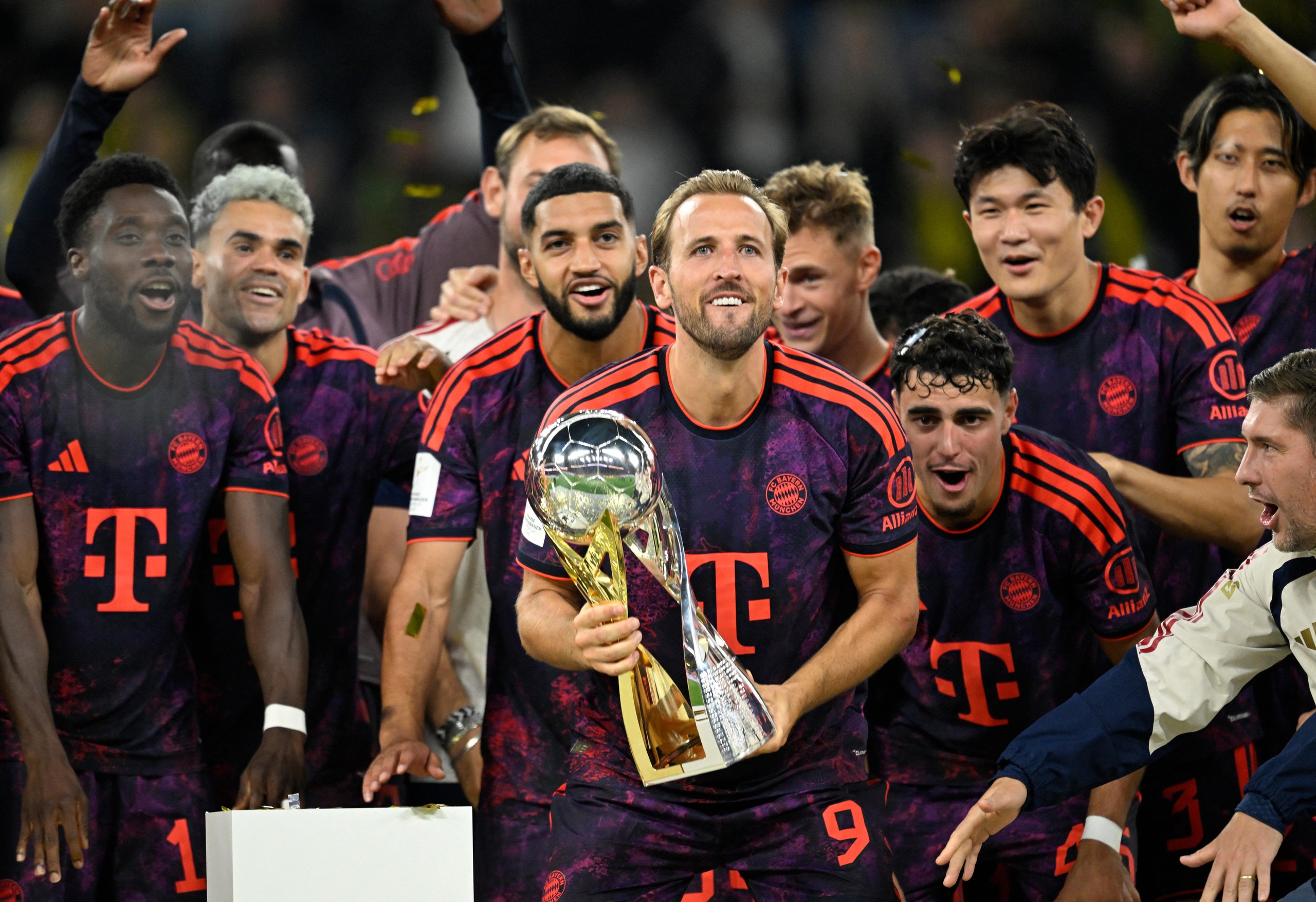 Harry Kane holds the trophy after Bayern win the Supercup against Dortmund.