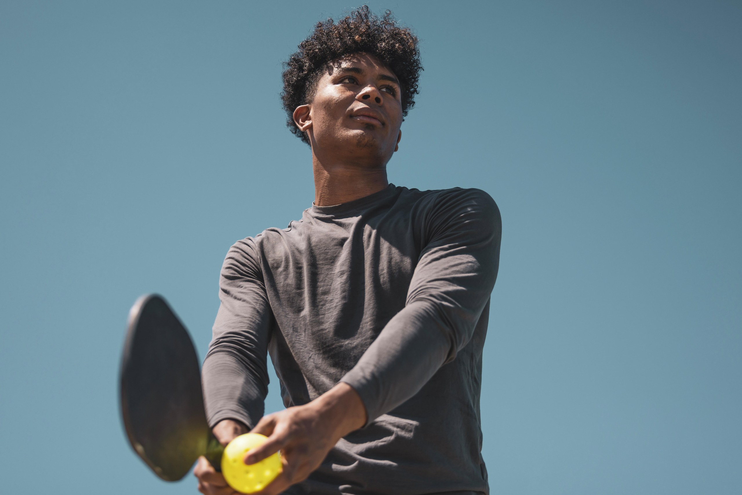 A pickleball player ready to serve in a game